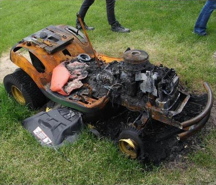 Lawn mower burned up sitting on grass